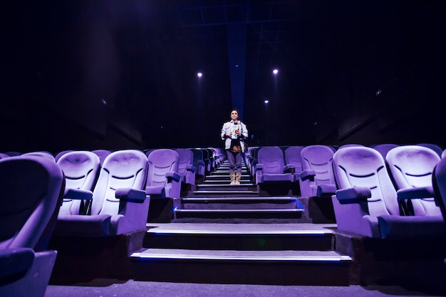 Photo femme dans la salle de cinéma éclairée