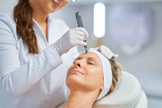 Femme dans un salon de beauté ayant un traitement de mésothérapie à l'aiguille