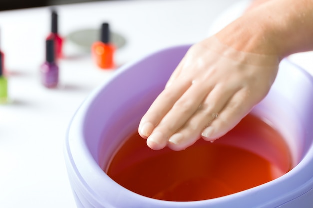 Femme dans un salon de beauté avec bain à la paraffine