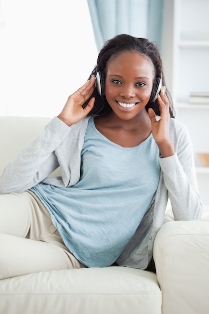 Femme dans le salon en écoutant de la musique