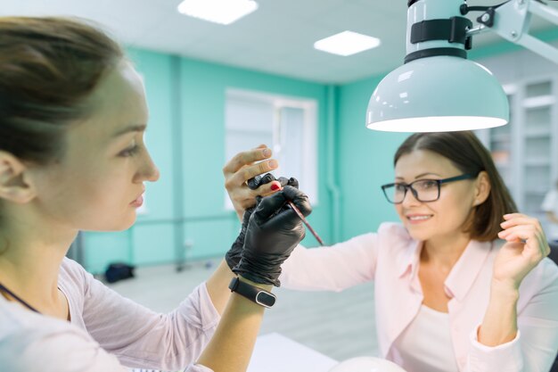 Femme dans un salon de manucure recevant une manucure par manucure