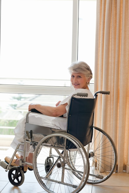 Femme dans son fauteuil roulant en regardant la caméra