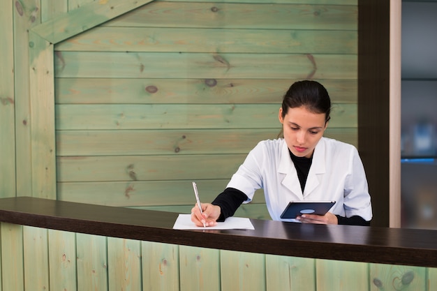 Femme dans un spa recpetion utilise textos tablet pc au client. Concept de beauté et de technologie.