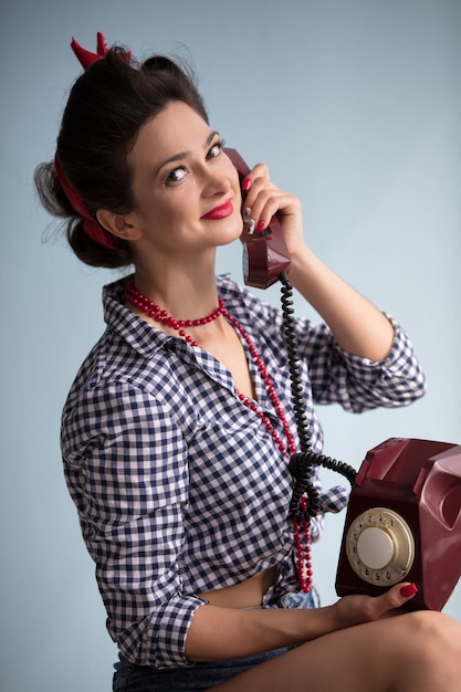 Femme dans le style des années 50 Retro femme tient un téléphone