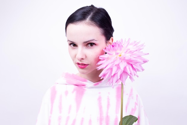 femme dans un sweat à capuche rose tenant une fleur rose