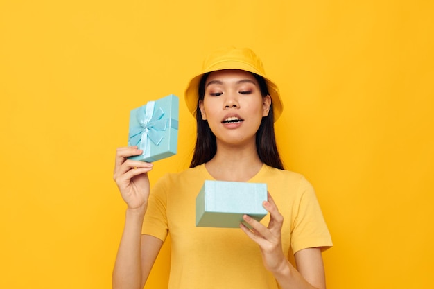 Femme dans un t-shirt jaune et un chapeau avec un modèle de studio cadeau inchangé