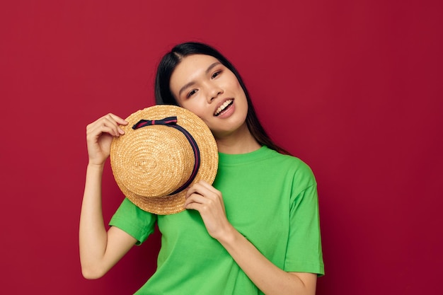 Femme dans un t-shirt vert faisant des gestes avec ses mains amusant fond rouge inchangé