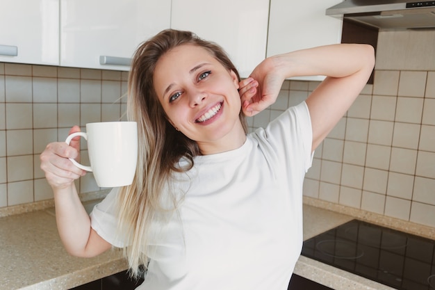 femme dans un tshirt blanc avec une tasse de café blanc