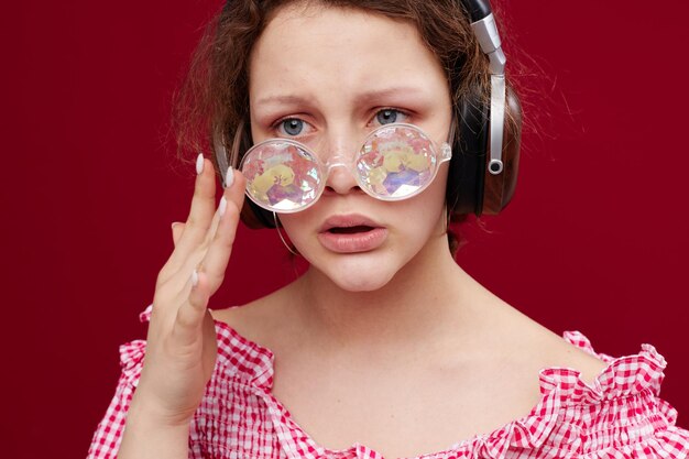 Femme dans une veste rose avec des lunettes d'écouteurs en forme de diamant