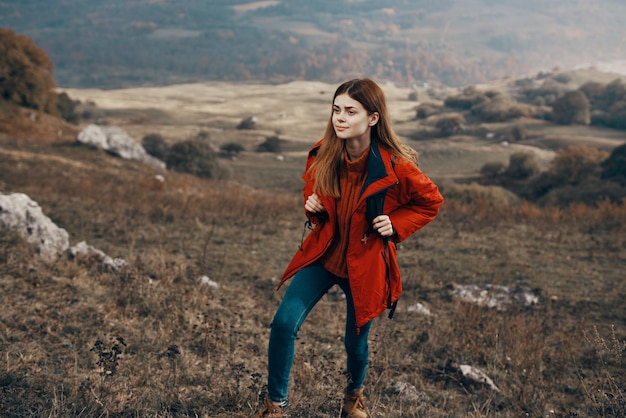 Femme dans une veste avec un sac à dos montagnes steppe paysage automne modèle de vêtements chauds