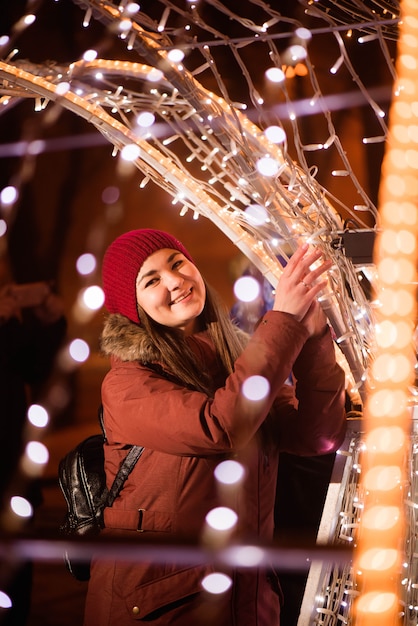 femme, dans, vêtements hiver, sur, lumières floues, près, lumières noël arbre