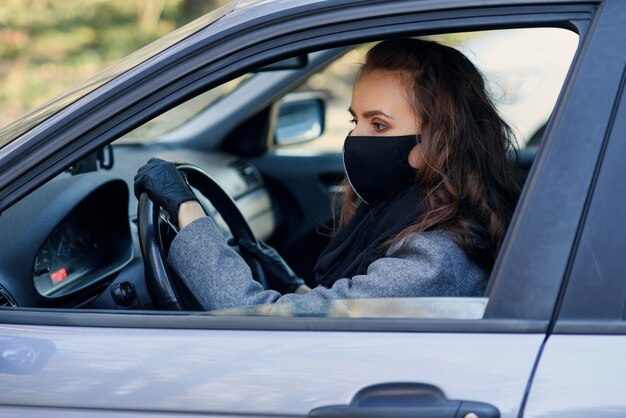 Femme dans la ville. Personne dans un masque. Thème du coronavirus. Femme près de la voiture.