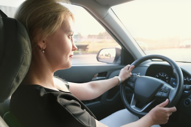 Femme dans une voiture en conduisant Photo de profil d'une belle femme blonde aux cheveux longs