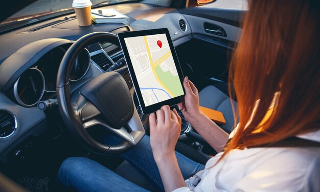 Photo femme dans une voiture avec une tablette dans les mains