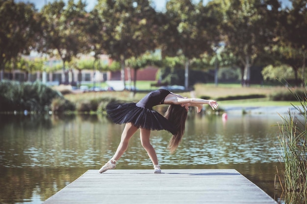 Photo une femme dansant le ballet sur la jetée au-dessus du lac