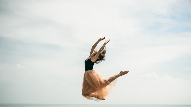 Une femme dansant sur la mer contre le ciel