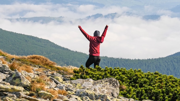 Femme debout au sommet de la montagne