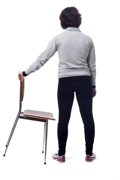 Femme debout sur une chaise avec son dos sur fond blanc