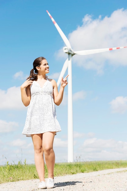 Une femme debout contre un moulin à vent