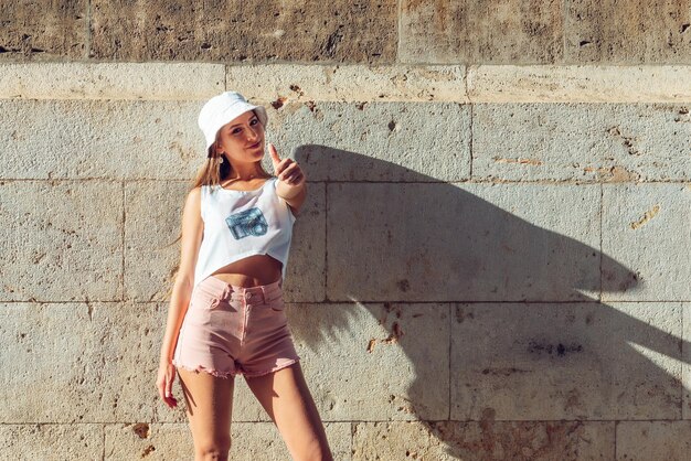 Une femme debout contre le mur.