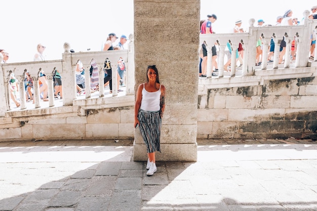 Une femme debout contre le mur.