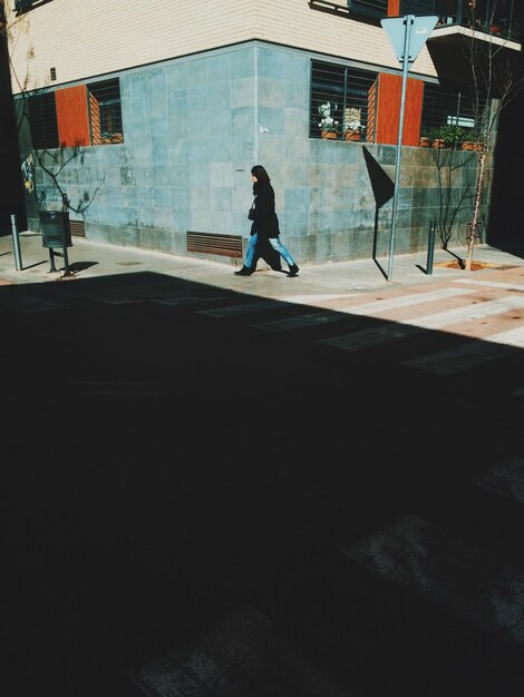 Une femme debout contre le mur.