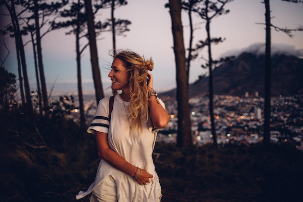 Une femme debout contre le paysage urbain