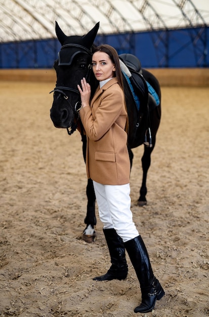 Une femme debout à côté d'un cheval noir