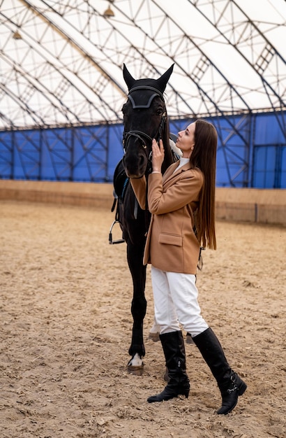 Une femme debout à côté d'un cheval noir