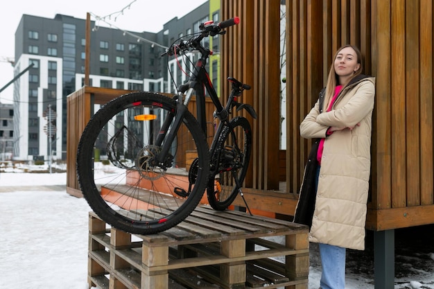 Femme debout à côté du vélo sur une plate-forme en bois