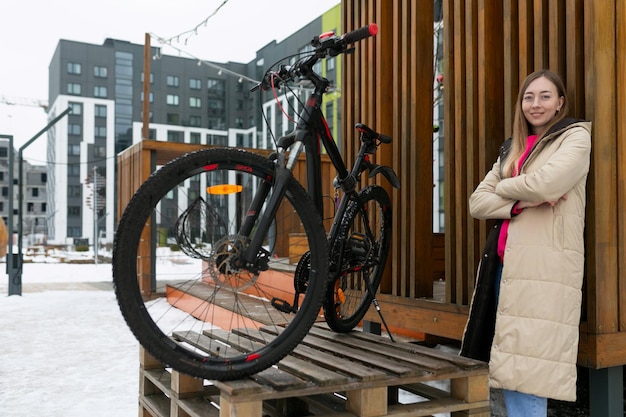 Femme debout à côté du vélo sur une plate-forme en bois