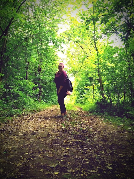 Photo une femme debout dans la forêt