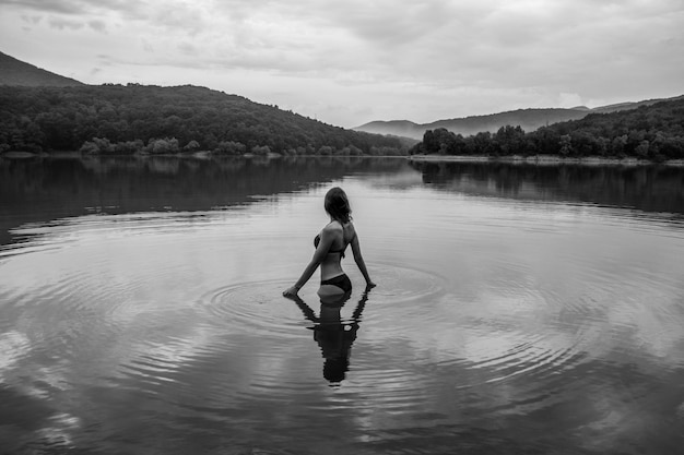 Une femme debout dans le lac contre le ciel