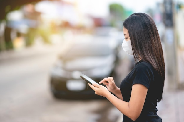 Femme debout dans la rue à l'aide d'un smartphone