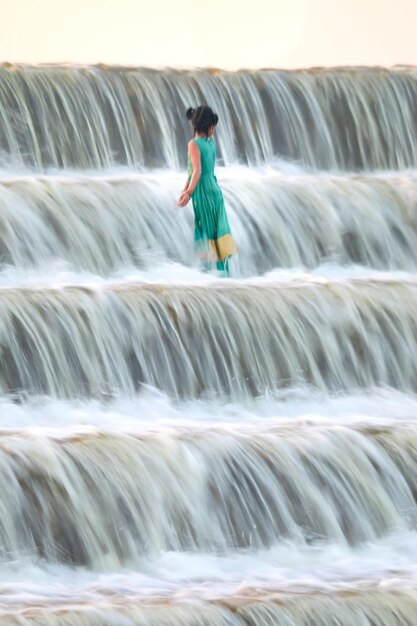 Photo une femme debout avec de l'eau multicolore