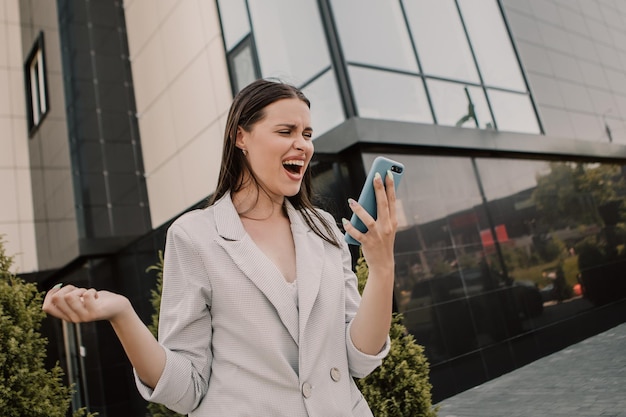 Femme debout à l'extérieur et criant sur téléphone mobile