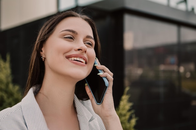 Femme debout à l'extérieur et parlant au téléphone mobile