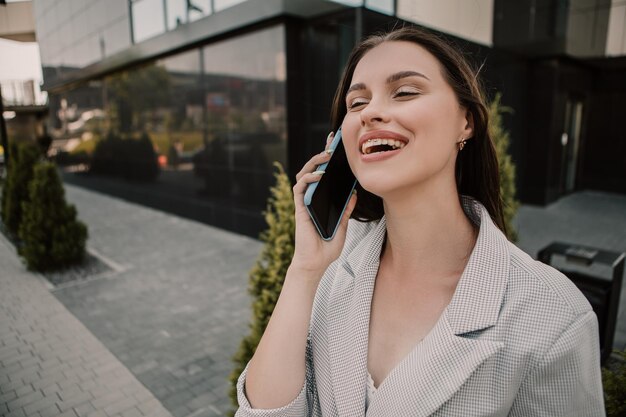 Femme debout à l'extérieur et parlant au téléphone mobile