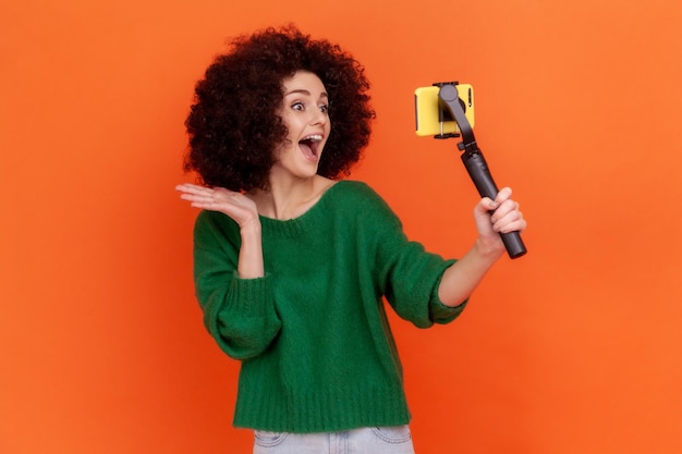 Photo une femme debout sur un fond orange.