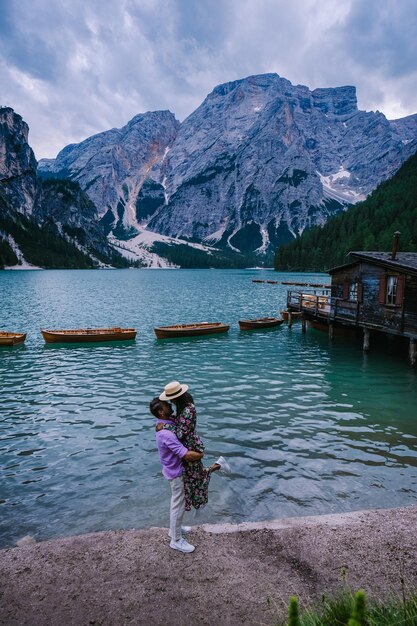 Une femme debout sur le lac par des montagnes enneigées contre le ciel