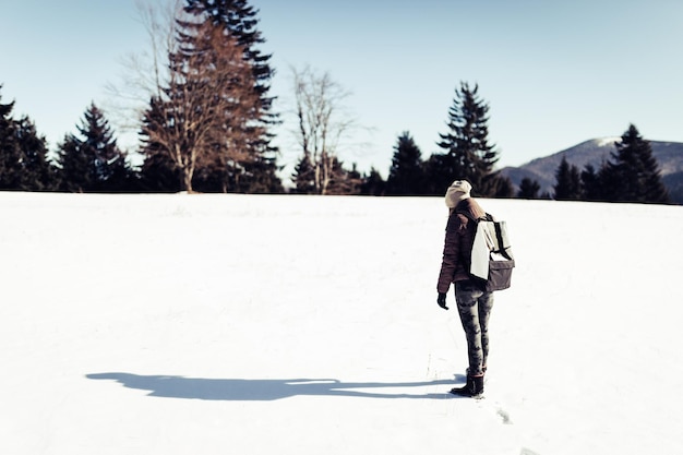 Une femme debout sur un paysage couvert de neige