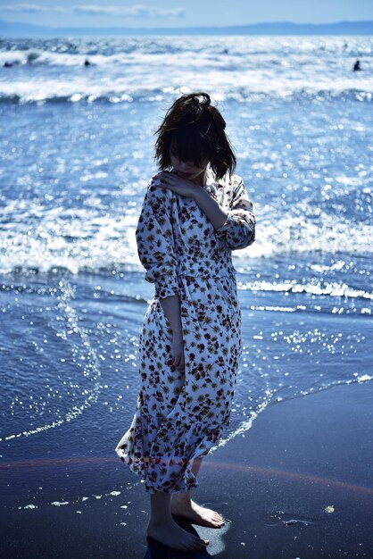 Photo une femme debout sur la plage