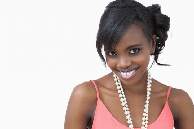 Femme debout portant un collier de perles en souriant