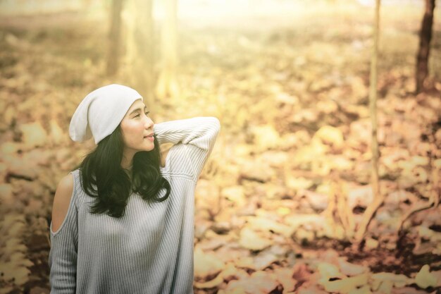 Femme debout et posant au parc d'automne