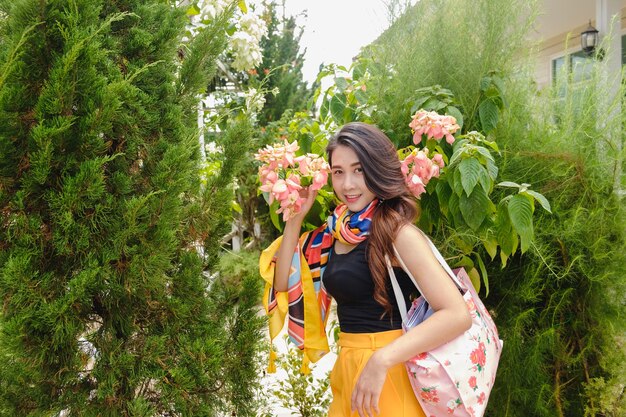 Une femme debout près des plantes.