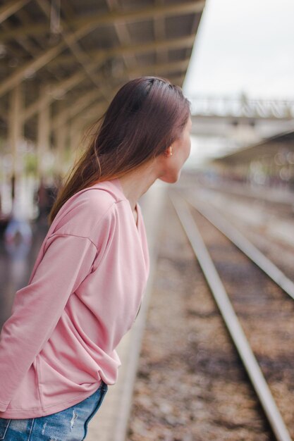 Photo une femme debout sur le quai de la gare.