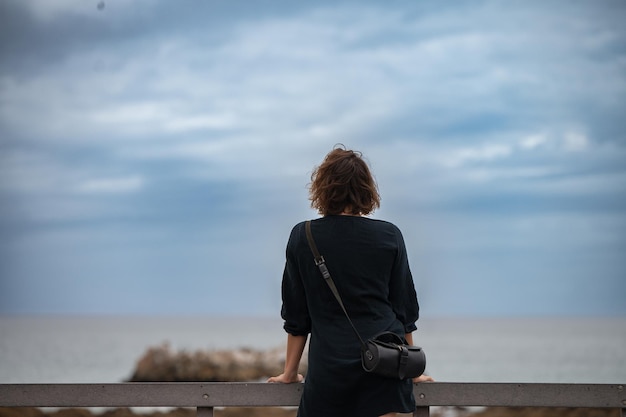 Femme debout et regardant la mer