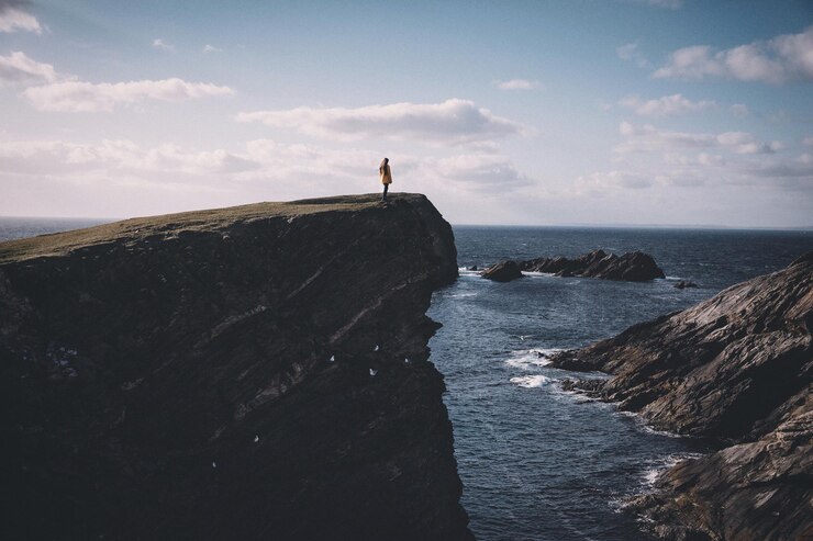 Photo une femme debout sur un rivage rocheux contre le ciel