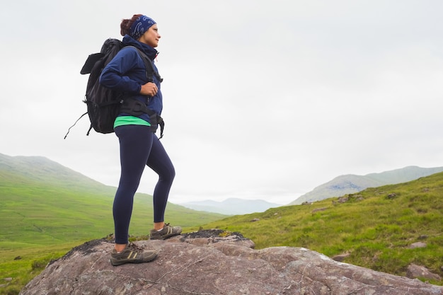 Femme debout sur le rocher en admirant la vue