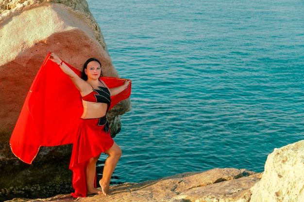 Photo une femme debout sur un rocher au bord de la mer